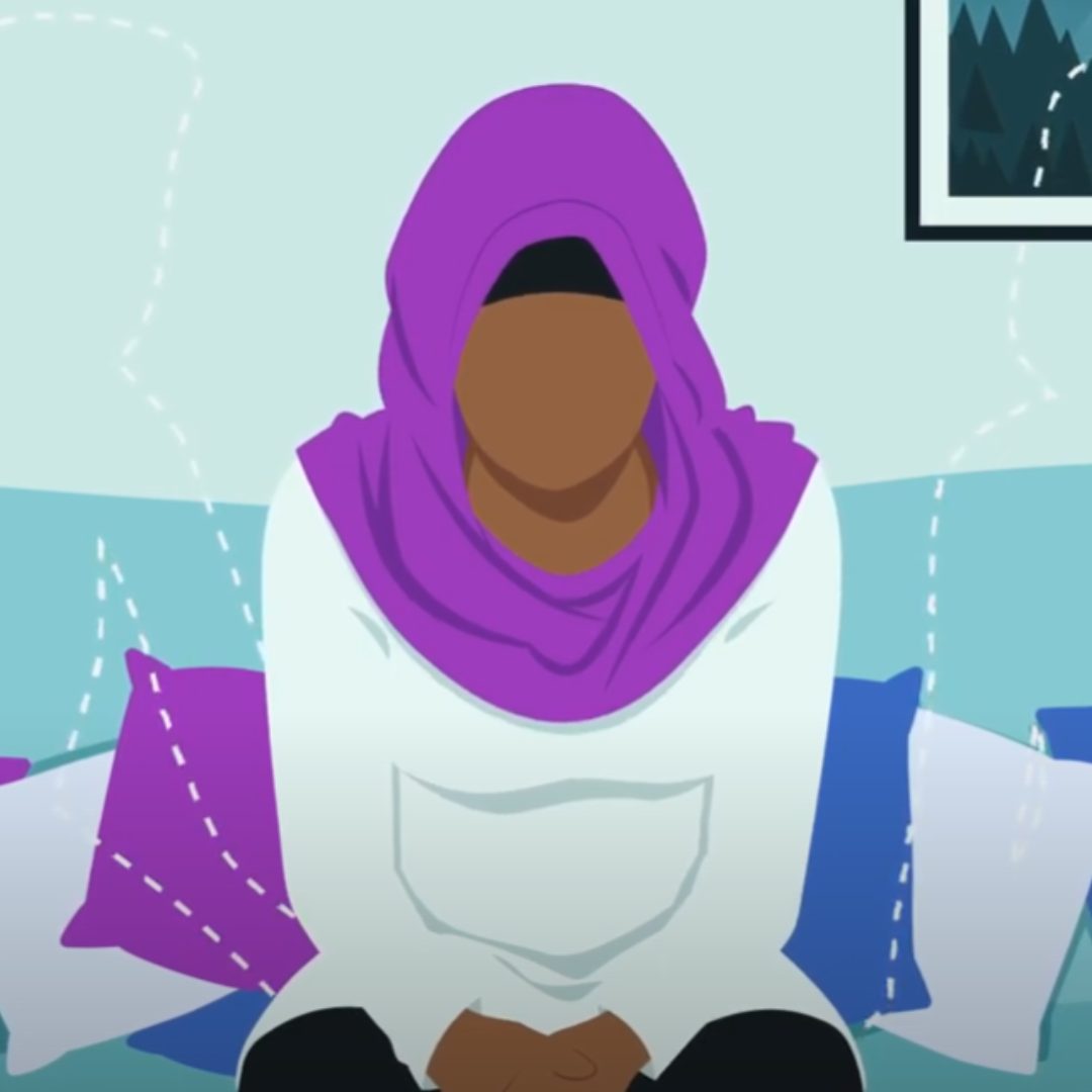 Illustration of a woman wearing a headscarf, sitting alone on a sofa. On either side of her are faint outlines of people, which suggests she is thinking about them.
